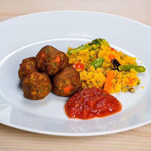 Grönsaksbullar med tomatsås på en bädd av couscous